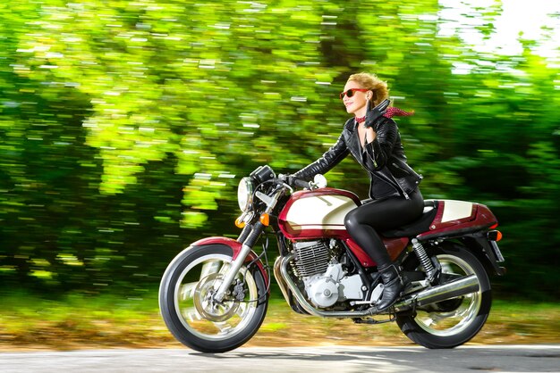 Biker-Mädchen in einer Lederjacke auf einem Motorrad