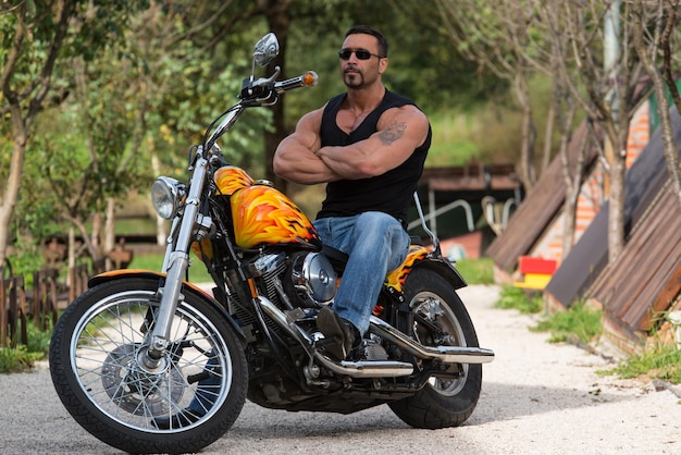 Biker Man Bodybuilder sitzt auf einem Fahrrad