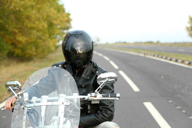 Biker Mann im schwarzen Helm sitzt auf Fahrrad