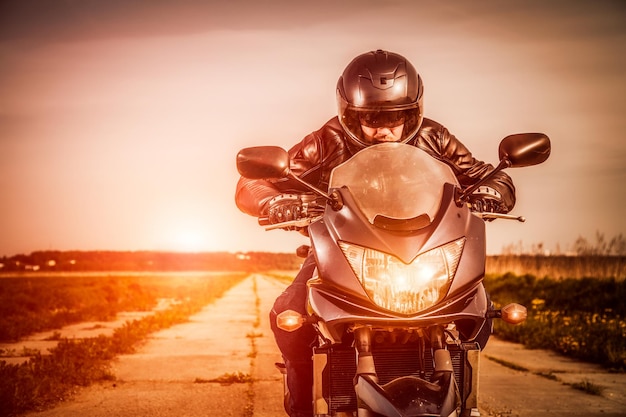 Biker mit Helm und Lederjacke auf der Straße