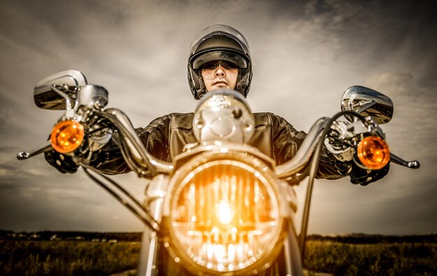 Biker mit Helm und Lederjacke auf der Straße