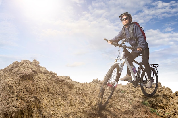 Biker montando en bicicleta en las montañas al atardecer