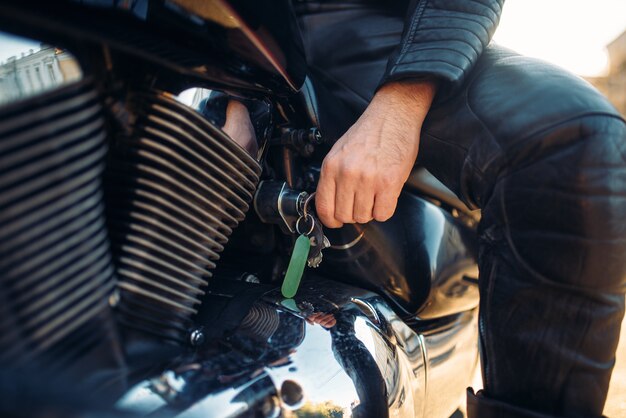 Biker steckt den Schlüssel in die Zündung des klassischen Hubschraubers.