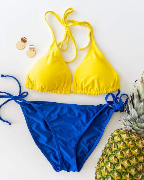 Foto bikini amarillo y azul con frutas tropicales piña