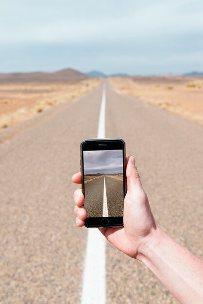 Bild auf dem Handy der Straße mitten in der Wüste.