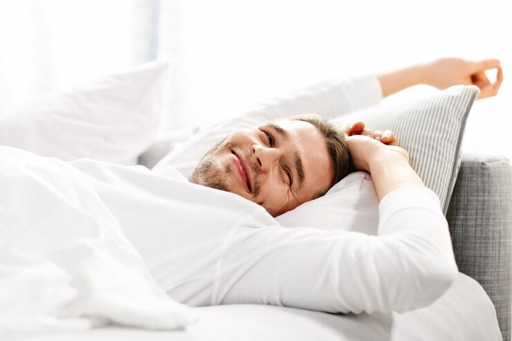 Foto bild, das einen jungen mann zeigt, der sich im bett streckt