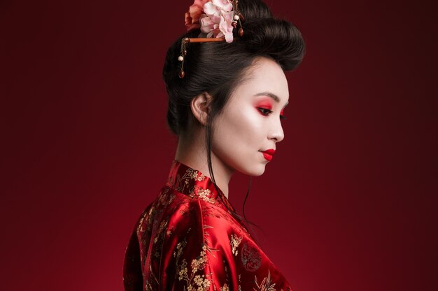 Bild der charmanten Geisha-Frau im traditionellen japanischen Kimono, die nach unten schaut
