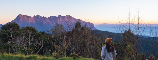 Bild der hinteren Ansicht des weiblichen Reisenden, der einen schönen Bergblick betrachtet