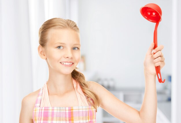 Bild der kleinen Hausfrau mit roter Kelle in der Küche