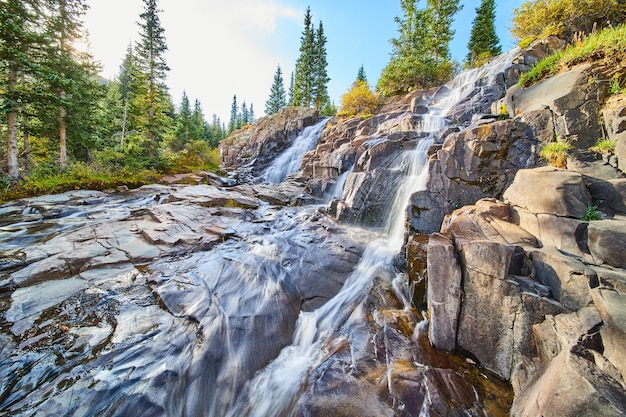 Bild der Nahaufnahme eines Paars von Wasserfällen über Stufen aus grauem Fels