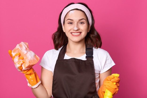 Bild der schönen gut aussehenden jungen Hausfrau, die Hausarbeit tut