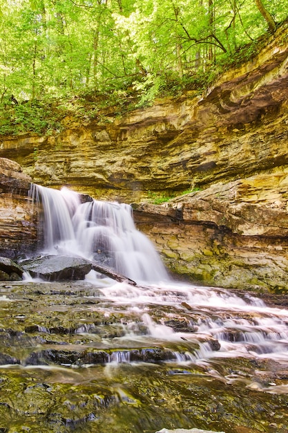 Bild der Vertikalen des Wasserfalls und der kaskadierenden Wasserfälle in der Schlucht mit üppigem grünem Wald