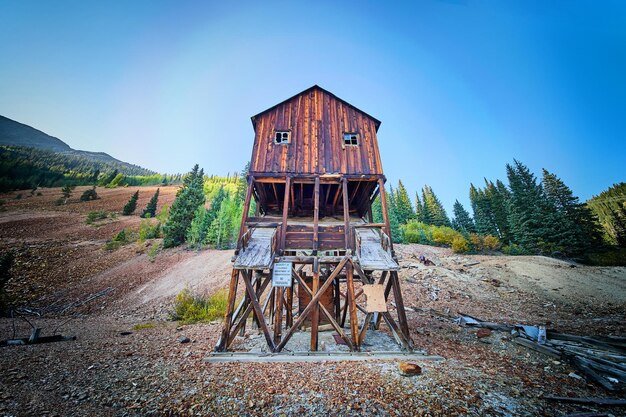 Bild des alten verlassenen Holzbergbaugebäudes, das in die leeren Berge versteckt ist