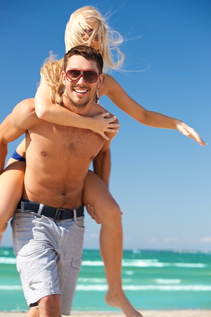 Bild des glücklichen Paares mit Sonnenbrille am Strand.