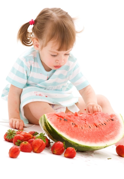 Bild des kleinen Mädchens mit Erdbeere und Wassermelone