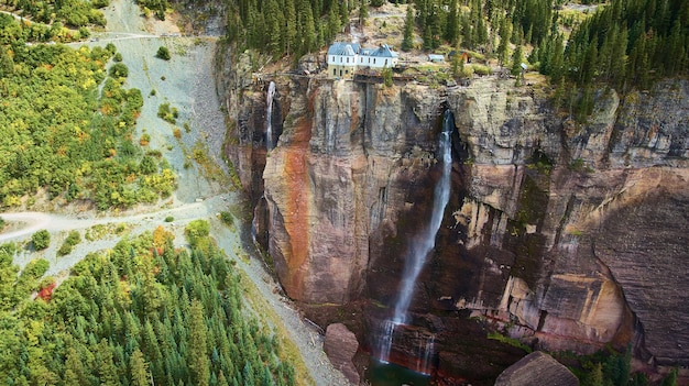 Bild des Kraftwerks oben auf der Klippe mit großem Wasserfall und Pinienwald