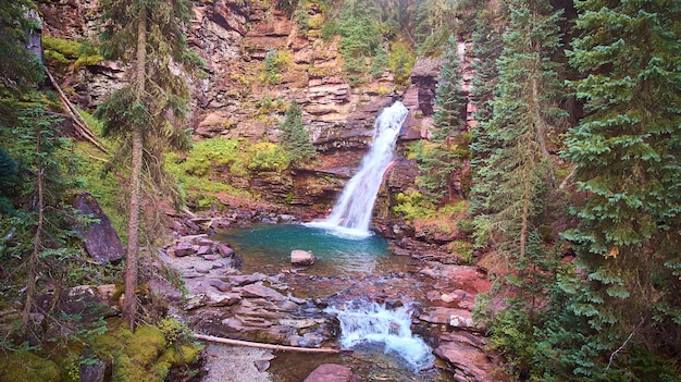 Bild des majestätischen versteckten Wasserfalls mit herrlichem blauem Wasser im Wald mit Klippen