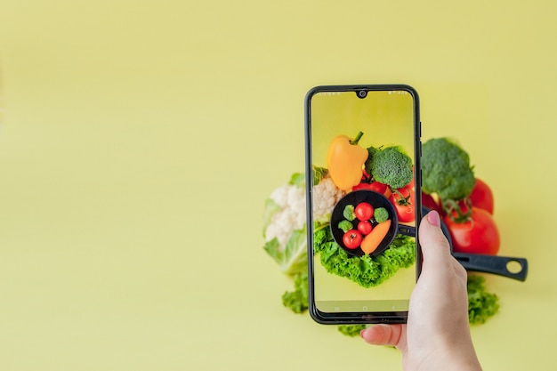 Bild des vegetarischen Essens auf Tisch durch Smartphone