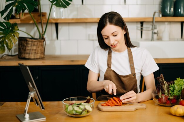 Bild einer asiatischen Frau, die Salat in der Küche zubereitet und gesundes Essen in einer Schüssel e