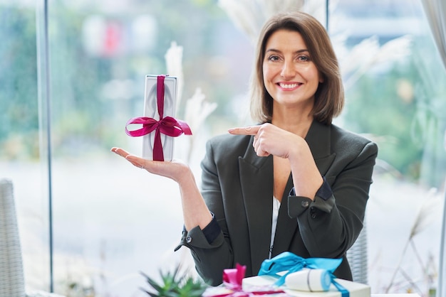 Bild einer Frau, die ein Geschenk im Restaurant hält