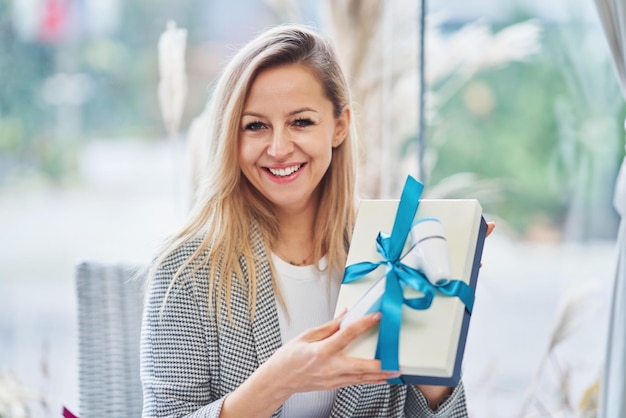 Bild einer Frau, die ein Geschenk im Restaurant hält