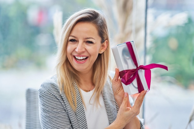 Bild einer Frau, die ein Geschenk im Restaurant hält