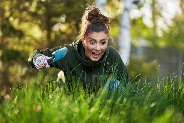 Bild einer Frau, die mit Werkzeugen im Garten arbeitet