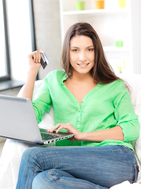Bild einer glücklichen Frau mit Laptop und Kreditkarte