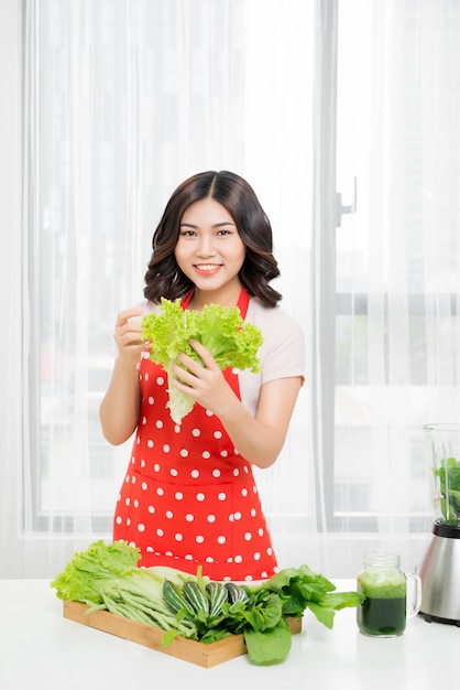 Bild einer glücklichen Frau mit Salat in der Küche