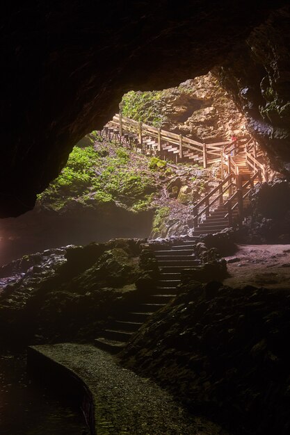 Bild einer großen Höhlenöffnung mit einer Treppe nach draußen