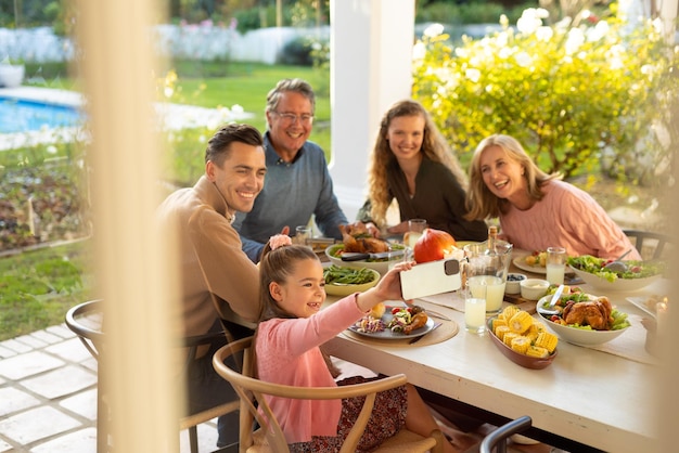Bild einer kaukasischen Familie aus mehreren Generationen, die nach dem Abendessen im Freien ein Selfie macht. Konzept für Familie und Zeit miteinander verbringen.
