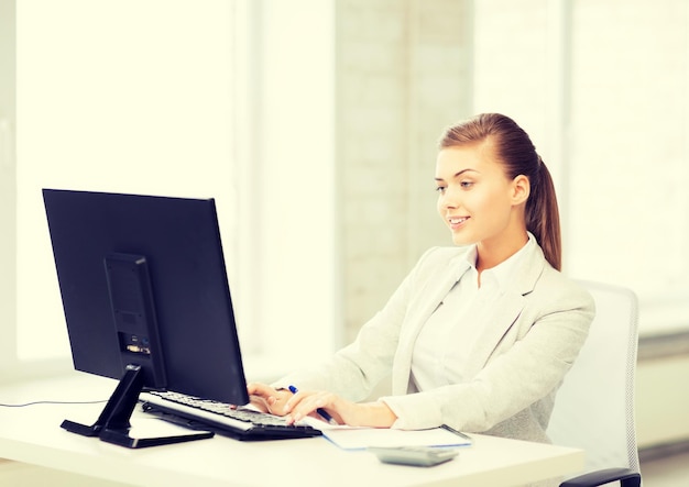 Bild einer lächelnden Geschäftsfrau mit Computer im Büro