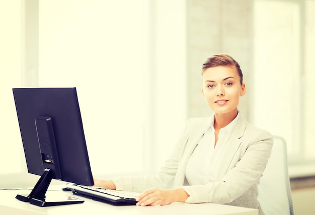 Bild einer lächelnden Geschäftsfrau mit Computer im Büro