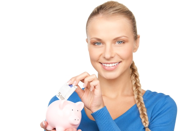 Bild einer schönen Frau mit Sparschwein und Geld