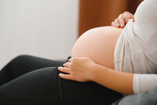 Bild einer schwangeren Frau, die ihren Bauch mit den Händen berührt