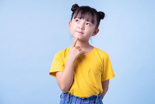 Bild eines asiatischen Kindes, das auf blauem Hintergrund posiert