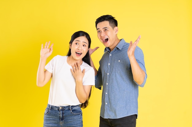 Bild eines asiatischen Paares, das auf gelbem Hintergrund posiert