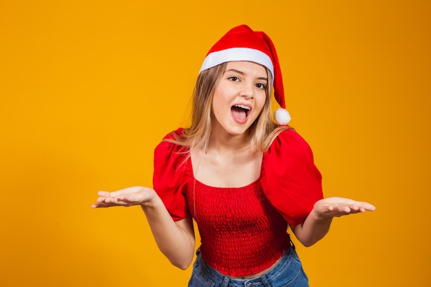 Bild eines aufgeregten, schreienden jungen Mannes, der isoliert auf gelbem Hintergrund steht, mit Weihnachtsmann-Hut, der die Kamera mit Kopienraum betrachtet.