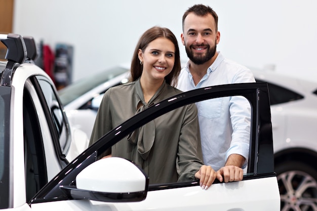 Bild eines erwachsenen Paares, das sich im Ausstellungsraum für ein neues Auto entscheidet