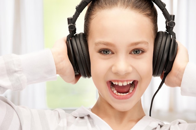Bild eines glücklichen Teenager-Mädchens in großen Kopfhörern