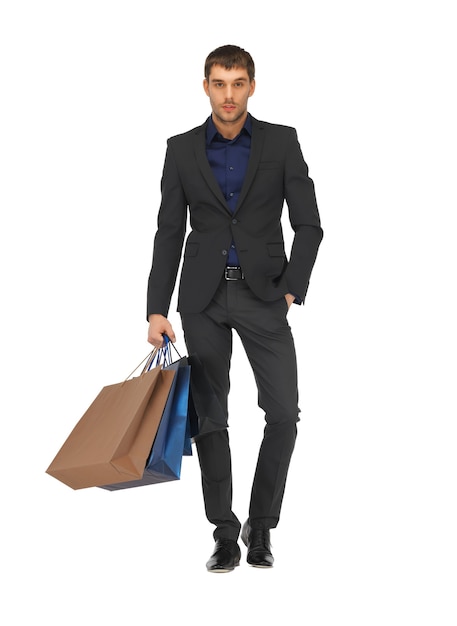 Bild eines gutaussehenden Mannes im Anzug mit Einkaufstüten