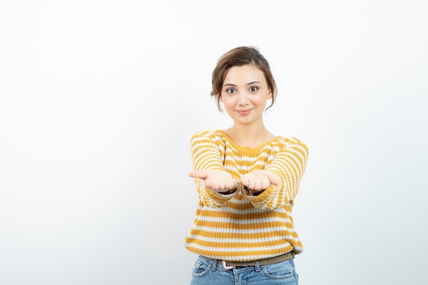 Bild eines jungen hübschen Frauenmodells, das geöffnete Handflächen zeigt. Foto in hoher Qualität