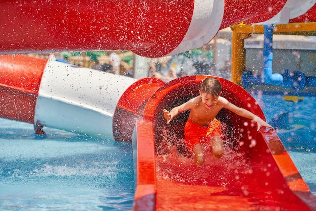 Foto bild eines kleinen jungen, der im outdoor-aquapark spielt