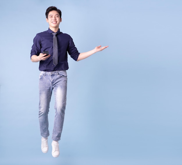 Bild in voller Länge des jungen asiatischen Geschäftsmannes auf blauem Hintergrund