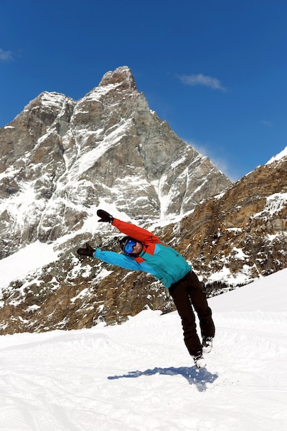 Bild in voller Länge eines springenden Skifahrers in Ausrüstung, auf dem hohen Berg