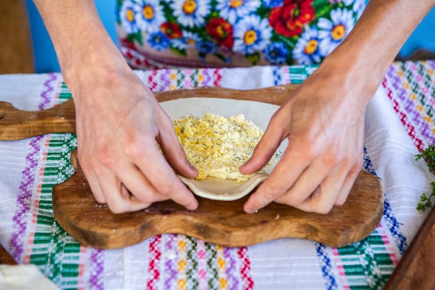 Bild mit den Händen einer Dame, die traditionelle rumänische frittierte Kuchen mit Käse kocht