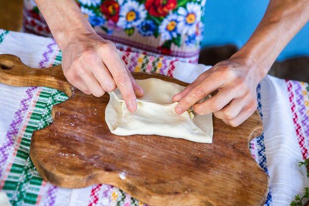 Bild mit den Händen einer Dame, die traditionelle rumänische frittierte Kuchen mit Käse kocht