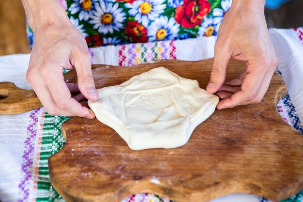 Bild mit den Händen einer Dame, die traditionelle rumänische frittierte Kuchen mit Käse kocht