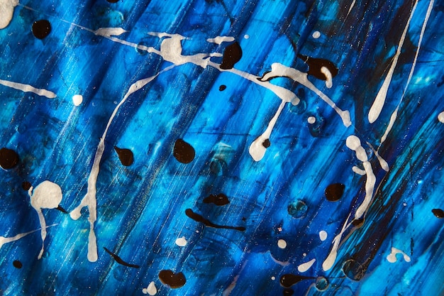 Bild von blauem Acrylgemälde auf Papier mit weißen und schwarzen Flecken