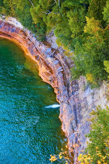 Bild von bunten Felsen mit Blick auf den Michigansee mit kabbeligem Wasser aus der Luft